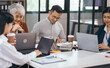 © Phushutter - Four asian people in an office, working together on laptops, discussing tasks. annual gathering where attendees share and discuss opinions, presentation teamwork group meeting laptop in boardroom