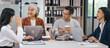 © Phushutter - Four asian people in an office, working together on laptops, discussing tasks. annual gathering where attendees share and discuss opinions, presentation teamwork group meeting laptop in boardroom