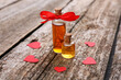 Bottles of love potion and paper hearts on wooden table