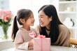 © Vilaysack - Happy Mother's Day, Daughter congratulates mother with flowers during a celebration with her on Mother's Day during the holiday at home. Generative AI