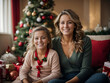 A portrait of a woman and her child in the soft glow of Christmas decorations depicts them enjoying a happy, heartwarming moment. 