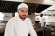 © Wavebreak Media - Portrait of confident caucasian male chef wearing hat standing in kitchen at cooking school