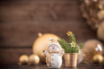 Wall Mural - Christmas golden decorations and snowman on dark wooden background