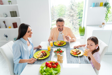 Wall Mural - Photo of peaceful friendly people sit dining room table eat homemade food drink fresh juice bright interior house inside