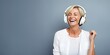 Smiling middle-aged woman, listening to music with headphones. Minimalist background with copy space