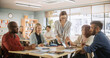 © Gorodenkoff - Grown-Up Men and Women Working in Groups for an Assignment in Specialty Development Center. Adult Classmates Working on a Team Assignment, Young Female Teacher Explaining the Exercise Objectibves
