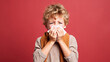 little boy with allergies or colds sneezes and covers his face with a handkerchief on a color background, illness, sick child, medicine, health, asthma, stuffy nose, virus, cough, treatment, flu