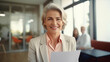 © Joshua - Smiling mature business hr woman holding cv at job interview. Happy mid aged professionall, manager, insurance agent, lawyer consulting clients sitting at work corporate office meeting woman