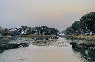 Beautiful views of sunset or sunrise on the lake in a luxury residential area. Water reflection. Sunset or sunrise landscape.