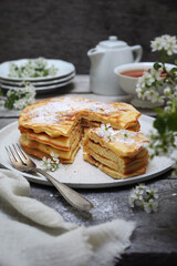 Wall Mural - French cuisine. Matefaim. Stack of sweet Apple Pancakes, cup of tea and white spring flowers