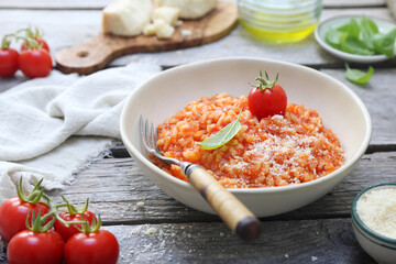 Italian cuisine. Plate of tomato risotto, olive oil, basil and cherry tomatoes