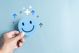 Fototapeta  - Hands holding blue happy smile face. mental health positive thinking and growth mindset, mental health care recovery to happiness emotion...