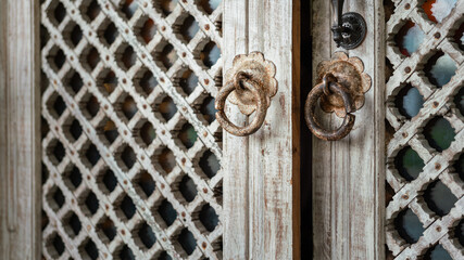 Wall Mural - An ancient designed rustic steel door knocker which is installed on wooden door. Object on the building for decoration.