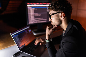 programmer are coding on a laptop in the dark. the concept of a developer or hacker.