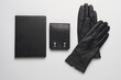Notebook with black leather cover and purse, gloves on gray background. Business concept. Top view. Flat lay