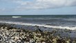 Brandung, Wellen peitschen gegen Steine am Strand der Ostsee