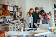© Geber86 - Group of diverse colleagues looking at a smartphone in a office