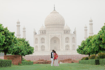 Wall Mural - couple  with the view of Taj Mahal in Agra, India