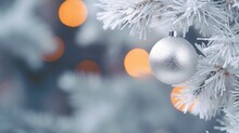  A Silver Ornament Hanging From A White Christmas Tree With A Blurry Background Of Orange And White Lights In The Background And A Blurry Fir Tree Branch.  Generative Ai