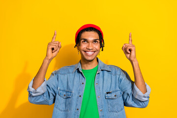 Wall Mural - Photo of funky nice guy man wear stylish denim clothes piercing earrings two arms direct empty space isolated on yellow color background