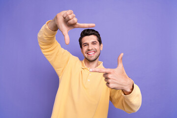 Sticker - Portrait of positive funky person toothy smile arms fingers demonstrate cadre gesture isolated on purple color background