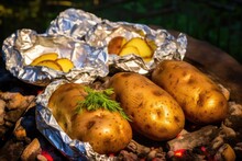 Baked Potatoes Ready For Eating Beside A Campfire