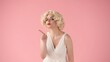 © kinomaster - The woman points her index finger to the side. Woman in the image of Marilyn Monroe in the studio on a pink background. Advertising, promo, copy space.