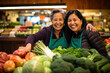 Two women vendors in a vibrant fruit and vegetable stall, sharing warm smiles with customers, creating a welcoming atmosphere