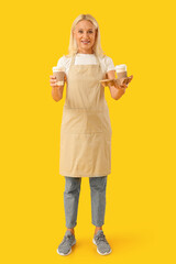 Sticker - Mature woman with cups of coffee on yellow background