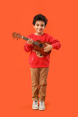 Canvas Print - Cute little boy playing guitar on orange background