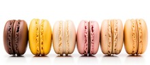 Five French macarons with various aromas isolated on white in pastel colors orange lemon caramel vanilla and coconut