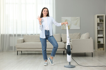 Canvas Print - Happy woman with steam mop showing ok gesture at home