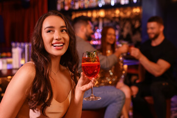 Canvas Print - Friends spending time together in bar. Beautiful woman with fresh alcoholic cocktail, space for text