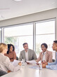 © insta_photos - Busy international professional executive business team diverse colleagues employees work group talking consulting planning project, having discussion at office corporate board room meeting. Vertical
