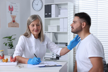 Sticker - Endocrinologist examining thyroid gland of patient at table in hospital