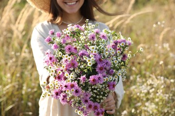 Wall Mural - Woman holding bouquet of beautiful wild flowers outdoors, closeup