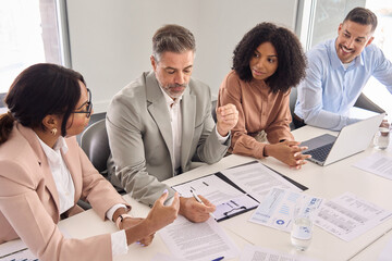 Aufkleber - Busy older Latin business man investor checking bank document at office team meeting with financial law experts team thinking of risks managing corporate paperwork. Consultancy advisory services.