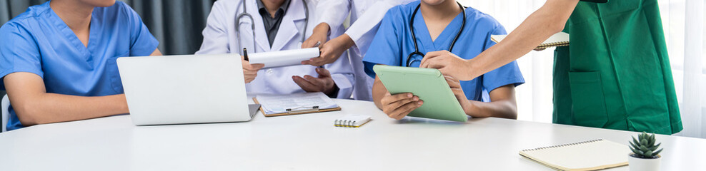 Professional various team of medical working and planning medical treatment at hospital table together. Teamwork lead to successful illness and sickness treatment. Panorama Rigid