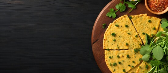 Canvas Print - Top view of gluten free chickpea flatbread made with socca on a cutting board over a green background