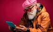 © Rendara Studio - Studio shot of mature man with white beard using digital tablet wearing trendy winter outfit