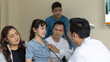 © Ron - Doctor uses stethoscope to check a girl's lung in his clinic. Doctor discusses with a girl's family for a medical treatment program.