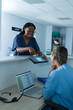© Wavebreak Media - Diverse female doctors discussing work, using tablet at reception desk at hospital