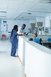 © Wavebreak Media - Diverse male and female doctors discussing work, using tablet at reception desk at hospital