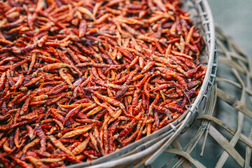 Dried red chilies in a wooden basket to be used as a seasoning in food.