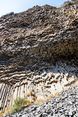 Sticker - symphony of the stones - bottom view of cliff from natural basalt columns in Garni gorge in Armenia on sunny autumn day