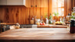 Of a wooden kitchen countertop on a blurred kitchen background. In the background are wooden cabinets, a window and various kitchen appliances.