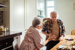 © Marko Geber - Woman comforting a distressed senior man in the kitchen
