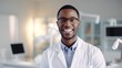 Portrait of smiling attractive african american young male doctor wearing in a white coat standing in a hospital background looking at camera. Good family doctor, therapist advice and friendly. ai.