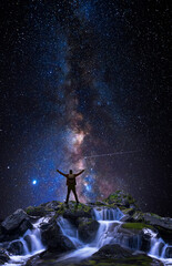 Wall Mural - man on top of a mountain with open arms in front of the universe
