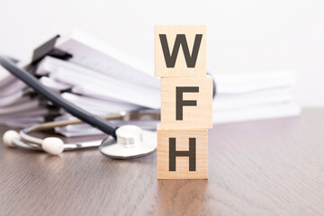 Poster - the word WFH is written on wooden cubes near a stethoscope on a white background.